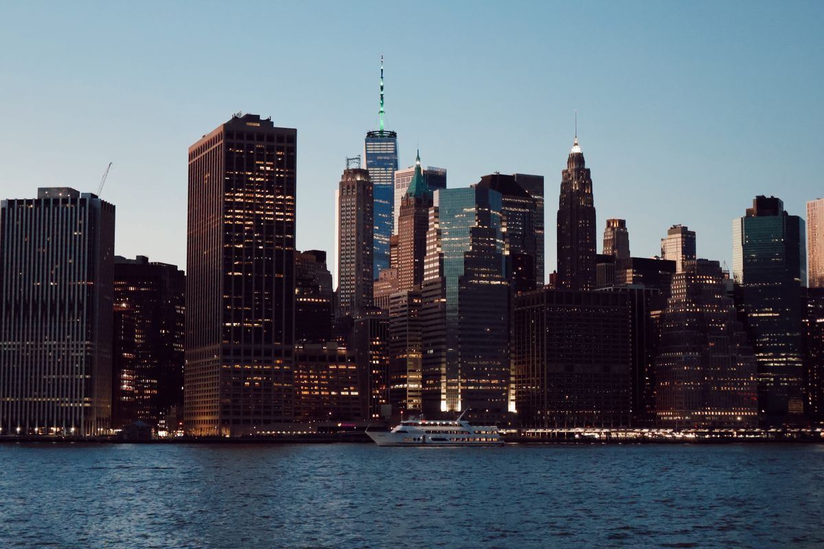 The Lower Manhattan skyline at dusk, seen across the East River.